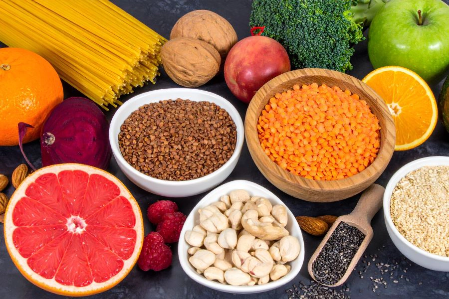 High dietary fiber health food concept with fruit, vegetables, whole wheat pasta, legumes, cereals, nuts and seeds with foods
